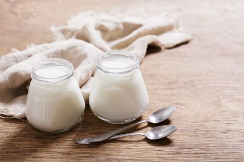 2 Joghurts mit zwei Teelöffeln - natürliche probiotische Nahrung